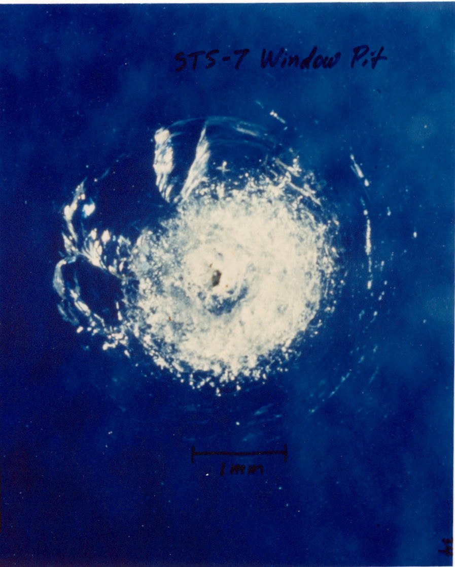 Close-up of an impact pit in a Space Shuttle window